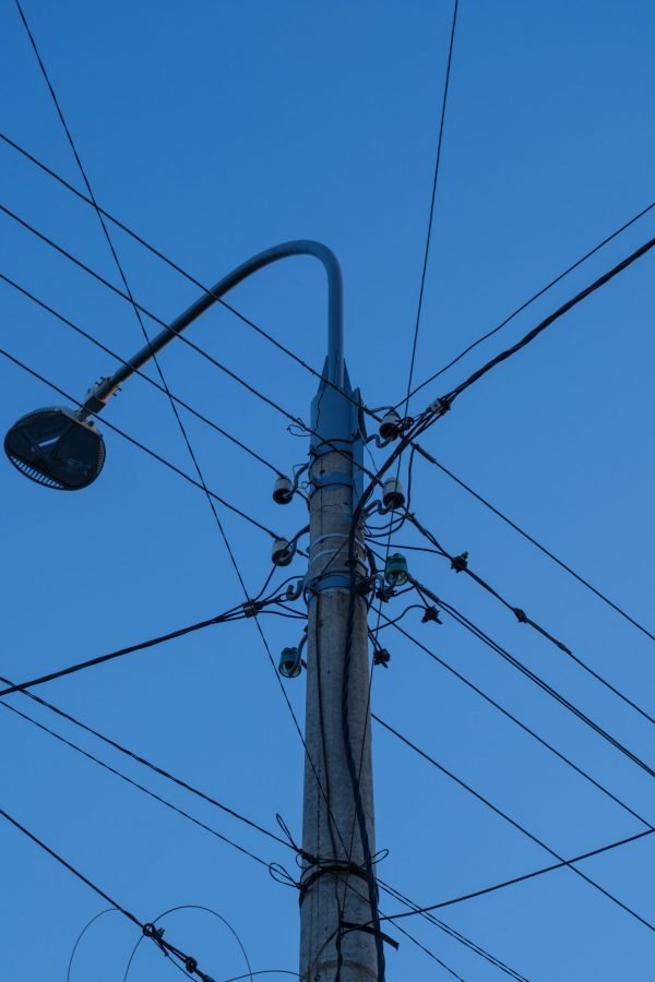 Imagem de um poste com cabos de transmissão de energia elétrica.